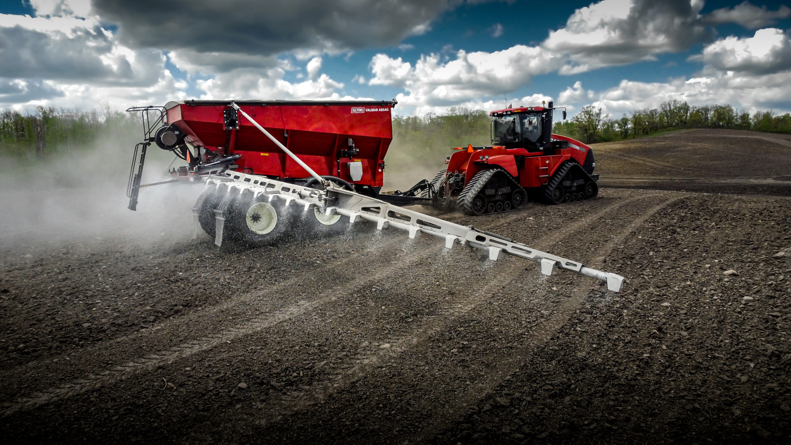 Red AB640 applicator working in a field with a tracked tractor